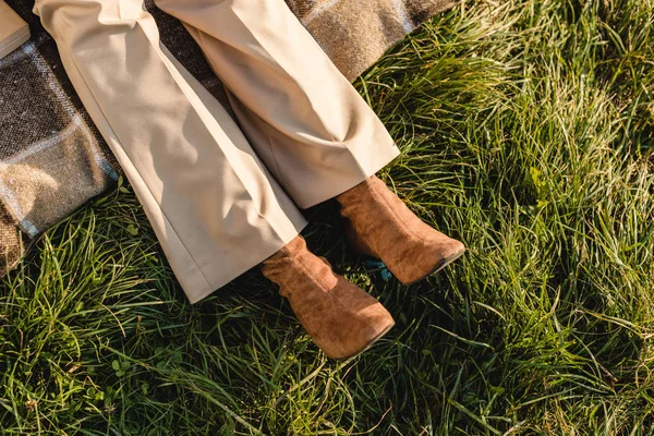 Low section of female legs in suede brown shoes on grass outdoors — Stock Photo