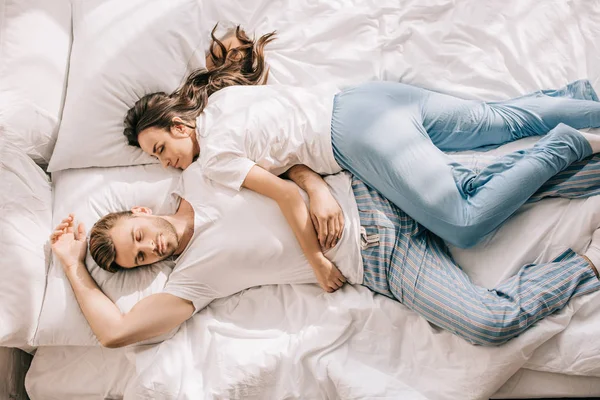 Draufsicht auf schönes junges Paar im Pyjama, das morgens im Bett schläft — Stockfoto