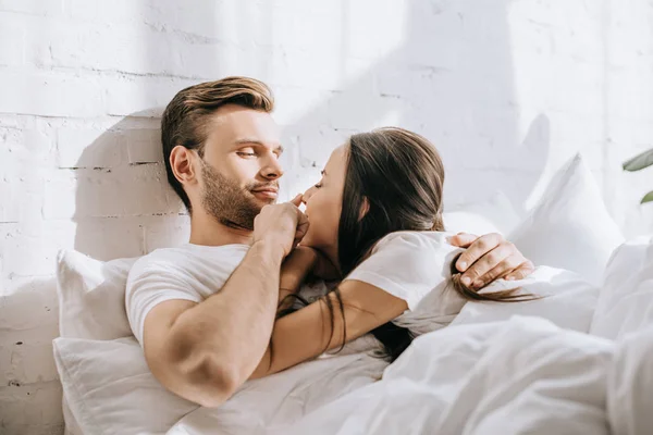 Heureux jeune couple se détendre au lit ensemble — Photo de stock