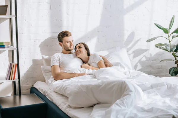 Heureux jeune couple se détendre au lit le matin — Photo de stock