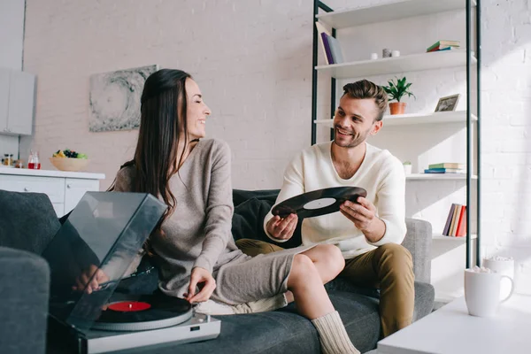 Heureux jeune couple écouter de la musique avec phonographe vinyle à la maison — Photo de stock