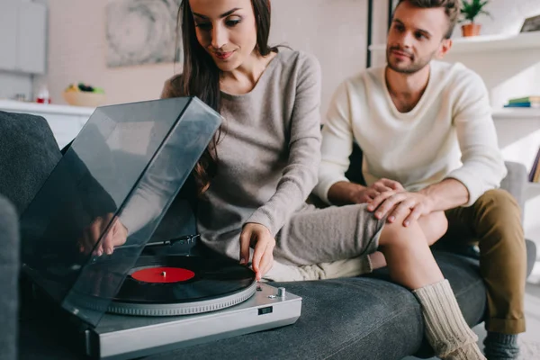 Belo jovem casal ouvindo música com fonógrafo de vinil em casa — Fotografia de Stock