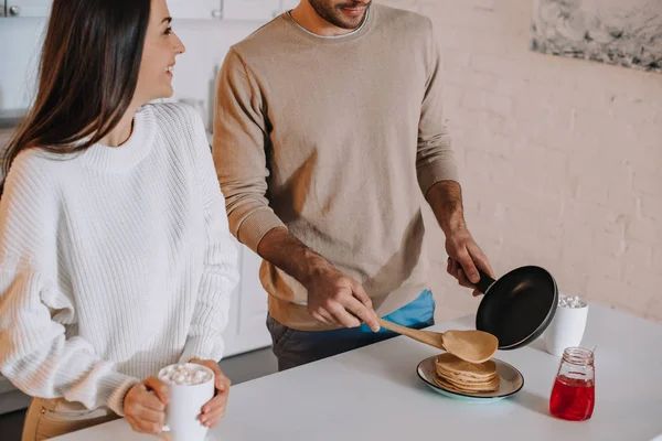 Cropped shot of young couple making pancakes for breakfast together at home — Stock Photo