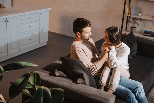 Romantica giovane coppia in chat mentre si rilassa sul divano di casa — Foto stock