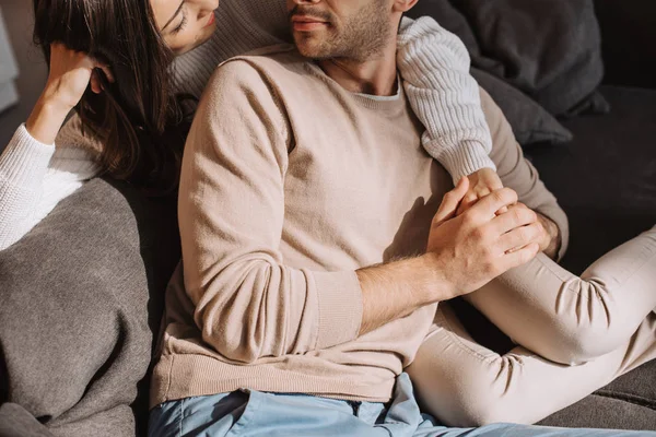 Corte tiro de belo jovem casal relaxando juntos no sofá em casa — Fotografia de Stock