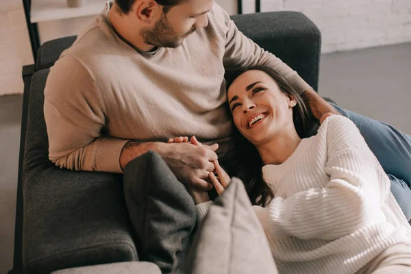 Happy young couple relaxing on couch together at home — Stock Photo