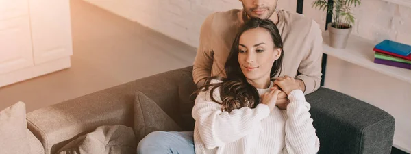 Corte tiro de jovem casal relaxando juntos no sofá em casa — Fotografia de Stock