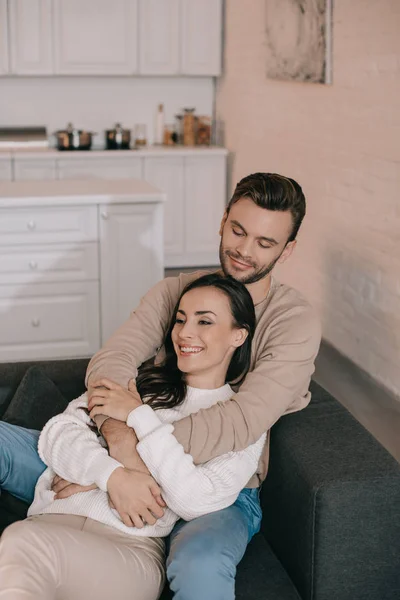 Vista de ángulo alto de la joven pareja sonriente relajarse en el sofá en casa - foto de stock