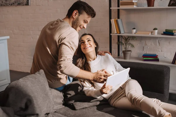 Schönes junges Paar mit Tablet zusammen auf der Couch zu Hause — Stockfoto