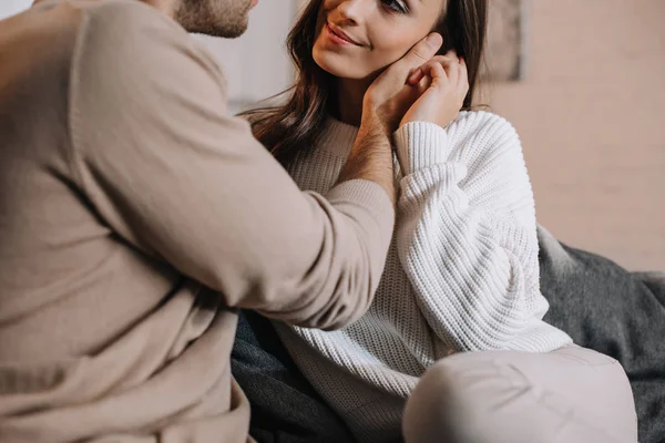 Plan recadré de beau jeune couple câlin sur le canapé à la maison — Photo de stock