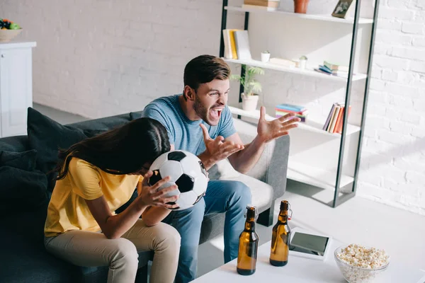 Ausdrucksstarkes wütendes junges Paar schaut Fußballspiel zu Hause — Stockfoto