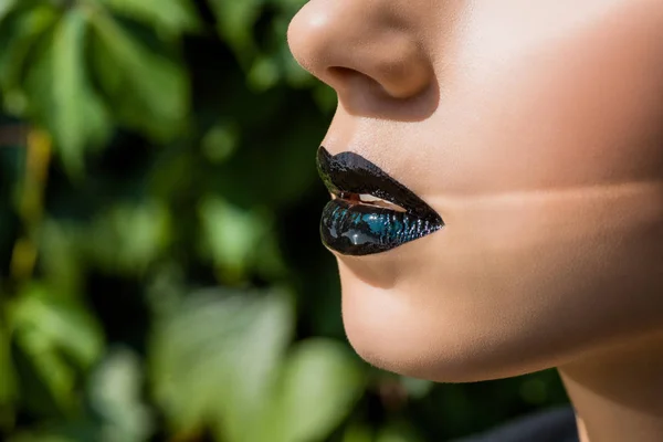Close up of female black shiny lips on green background — Stock Photo
