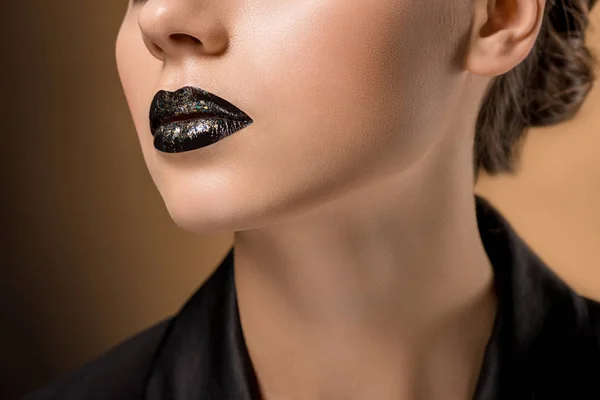 Nahaufnahme einer jungen schönen Frau mit glitzernden schwarzen Lippen — Stockfoto