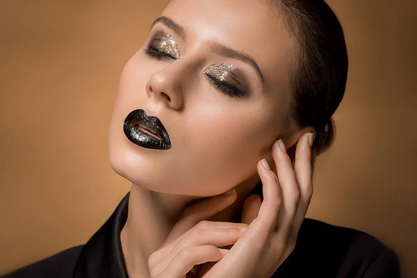 Young beautiful woman with glittery makeup and hands near face — Stock Photo