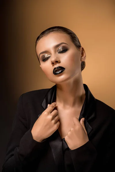 Young beautiful woman with glittery makeup holding black jacket — Stock Photo