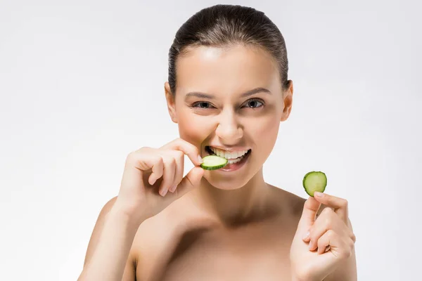 Junge schöne Frau beißt Gurkenscheibe — Stockfoto