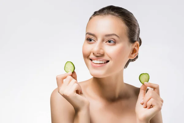 Joven sonriente mujer sosteniendo rodajas de pepino - foto de stock