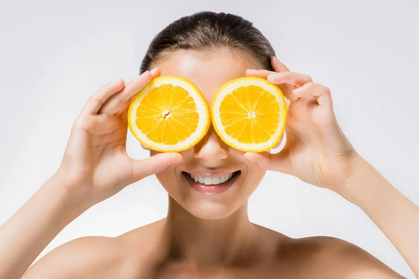 Jovem mulher sorridente com fatias de laranja nos olhos — Fotografia de Stock