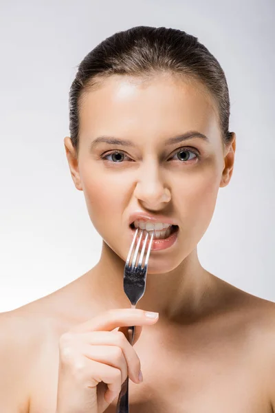 Young beautiful woman holding silver fork near teeth — Stock Photo