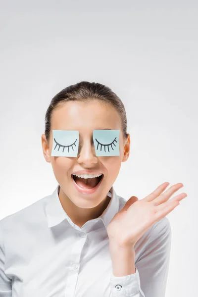 Jeune femme souriante avec des notes collantes sur les yeux et les cils dessinés — Photo de stock