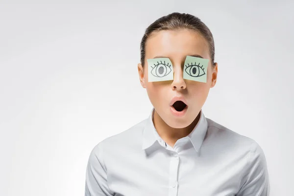 Mujer divertida joven con notas pegajosas y ojos abiertos dibujados - foto de stock