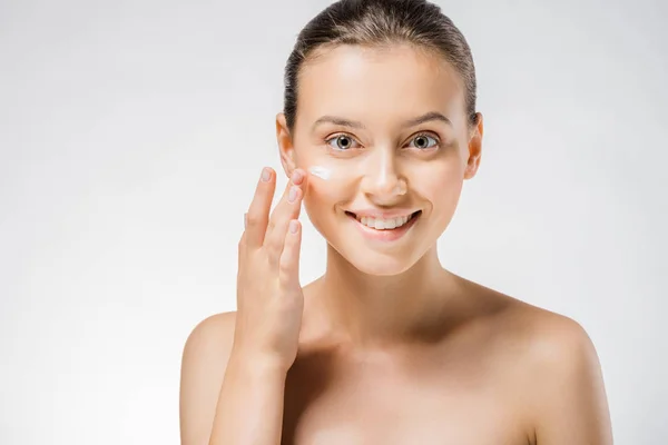Joven hermosa mujer aplicando crema blanca en la cara — Stock Photo