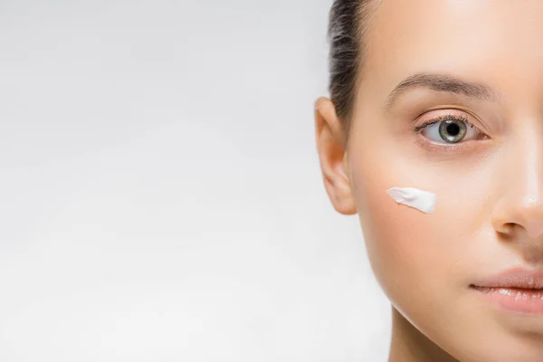 Jeune femme avec crème faciale blanche sur la joue — Photo de stock