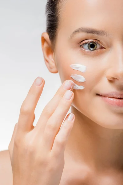 Jovem bela mulher aplicando creme branco com os dedos na bochecha — Fotografia de Stock