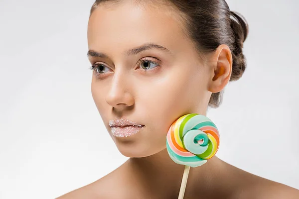 Mujer atractiva joven con azúcar en los labios y piruleta de colores - foto de stock