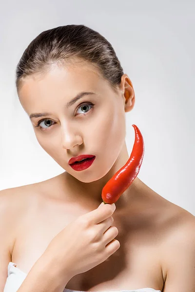 Jeune belle femme avec des lèvres rouges tenant piment près du visage — Photo de stock