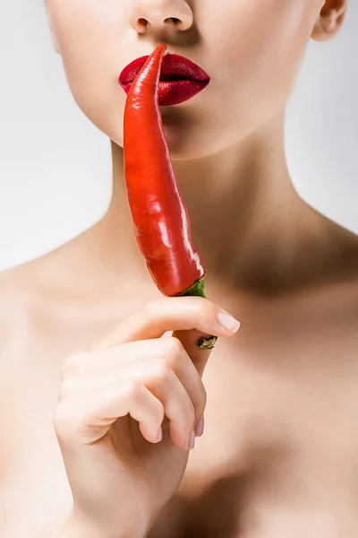 Junge schöne Frau mit roten Lippen, die Chilischote in der Hand hält — Stockfoto