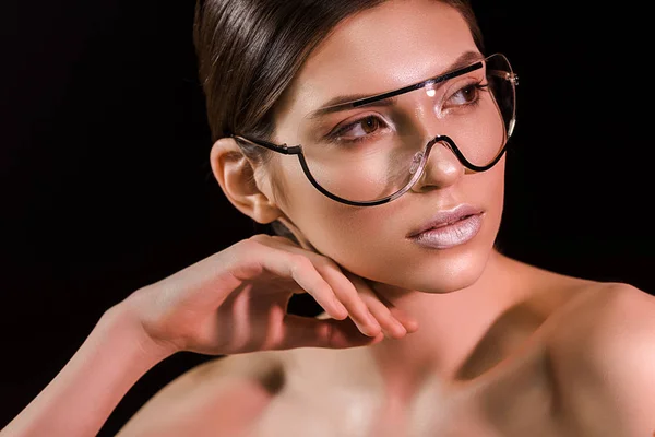 Portrait of attractive young woman in fashionable eyeglasses with bare shoulders isolated on black — Stock Photo