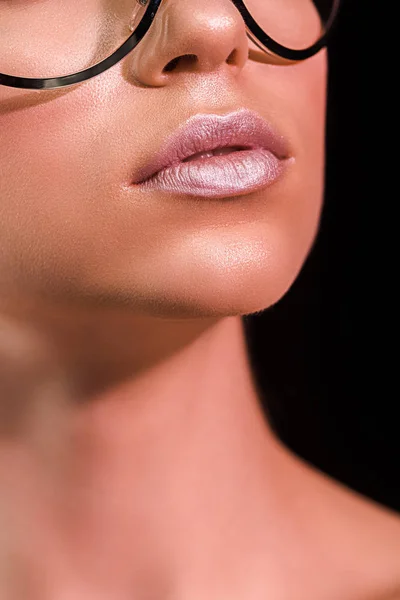 Tiro recortado de mujer con lápiz labial rosa en los labios aislados en negro - foto de stock