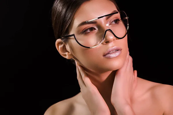 Portrait de femme attrayante coûteuse dans des lunettes élégantes regardant loin isolé sur noir — Photo de stock