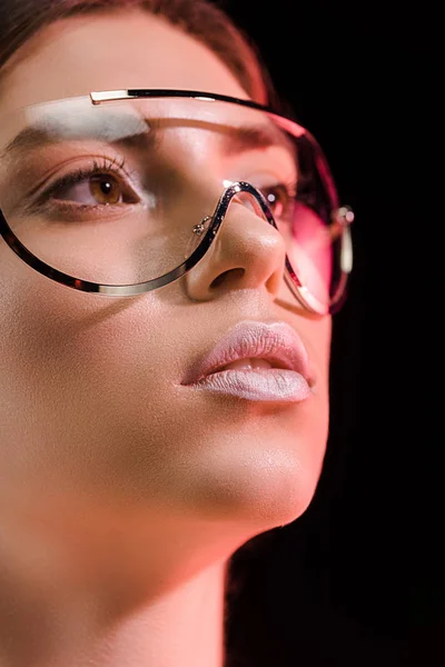 Portrait de belle femme en lunettes à la mode regardant loin isolé sur noir — Photo de stock