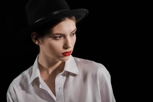 Retrato de modelo na moda em camisa branca e chapéu preto isolado em preto — Fotografia de Stock