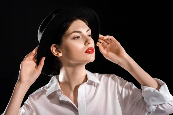 Portrait de modèle à la mode en chemise blanche et chapeau noir isolé sur noir — Photo de stock