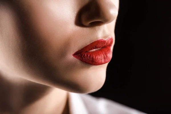 Partial view of woman with red lips isolated on black — Stock Photo