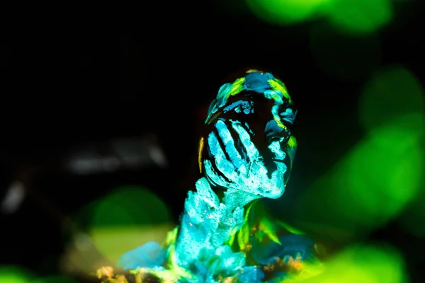 Model with colorful neon paints on body posing on black backdrop — Stock Photo