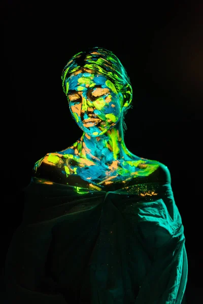 Modèle avec des peintures au néon colorées sur le corps posant sur fond noir — Photo de stock