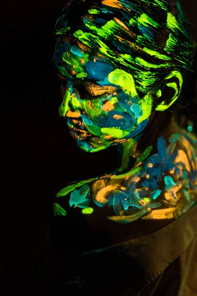 Seitenansicht der Frau gemalt mit bunten UV-Farben auf schwarzem Hintergrund — Stockfoto