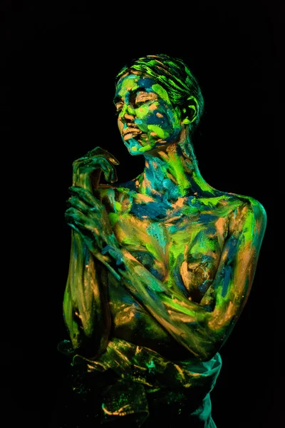 Portrait of woman painted with bright neon paints on black backdrop — Stock Photo