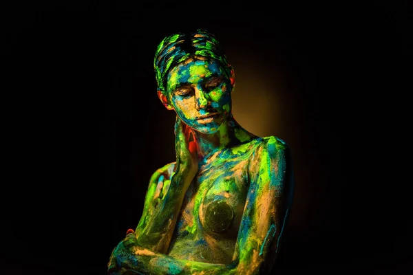 Portrait of beautiful woman with colorful ultraviolet paints on body on black backdrop — Stock Photo