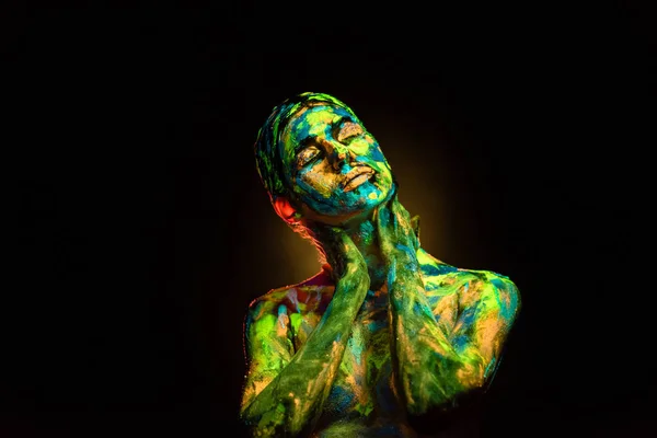 Retrato de mulher bonita com tintas ultravioletas coloridas no corpo no fundo preto — Fotografia de Stock