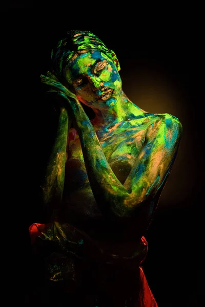 Portrait de belle femme avec des peintures ultraviolettes colorées sur le corps sur fond noir — Photo de stock