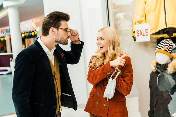Chica sorprendida mostrando super venta con 70 por ciento de descuento en escaparate en el centro comercial - foto de stock