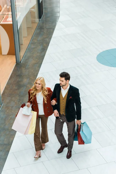 Overhead view of young customers with shopping bags walking in shopping mall — Stock Photo