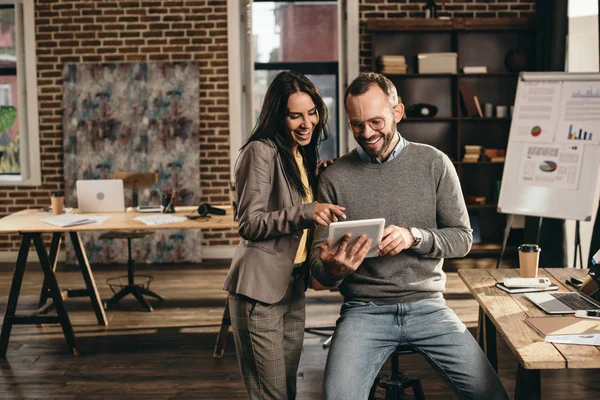 Couple of smiling colleagues discussing work at modern loft office — Stock Photo