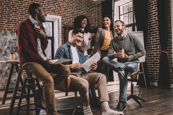 Multiethnische Gruppe von Mitarbeitern lächelt und diskutiert gemeinsam neues Projekt in modernem Loft-Büro — Stockfoto