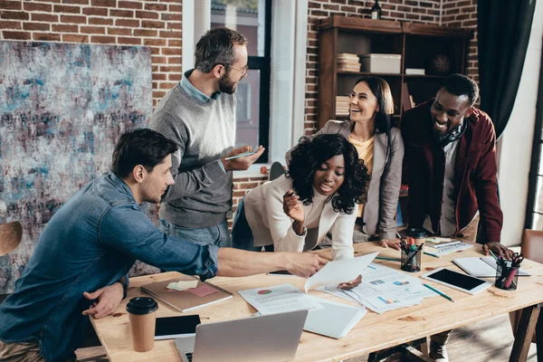 Smiling multiethnic group of colworkers having meeting and discussing together new project in modern loft office — Stock Photo